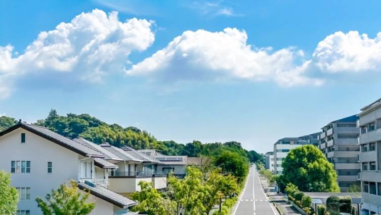 丘の上まで続くまっすぐな道路と住宅街